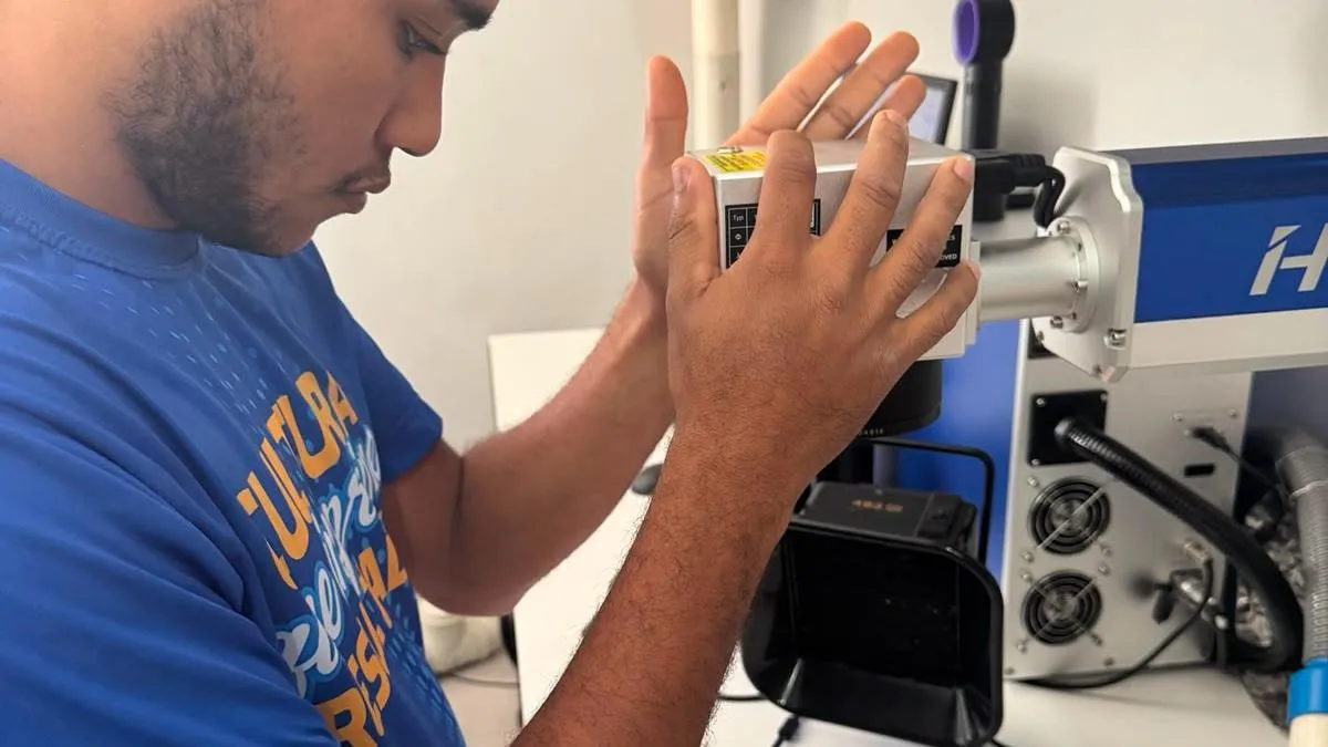 Colaborador ajustando equipamento de gravação e personalização.
